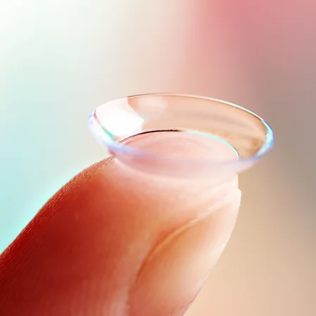 A contact lens balancing on the tip of a finger